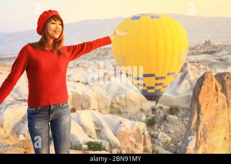 Weicher Fokus auf asiatische Frau auf fantastische Landschaft mit Heißluftballons in frühen Moning in Cappadocia, Türkei Stockfoto