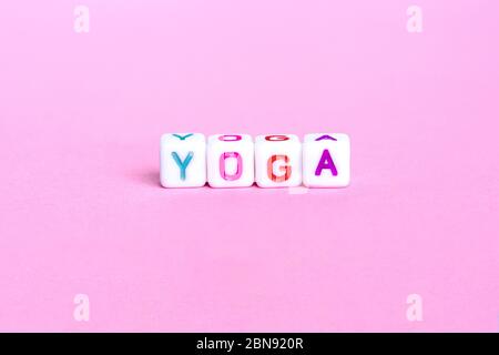 Das Wort Amore - Liebe auf Italienisch.mit Text Yoga auf einem rosa Hintergrund. Konzeption. Stockfoto