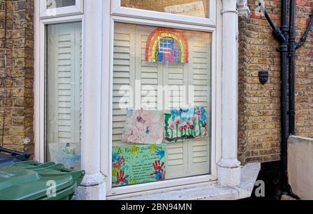 London, Großbritannien - 04. April 2020: Handgezeichneter Regenbogen und Poster mit Dankesschreiben an NHS und wichtige Arbeiter, die im Haus in Lewisham ausgestellt sind Stockfoto