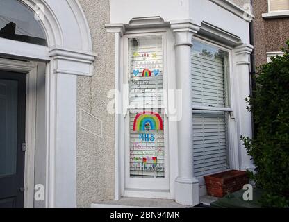 London, Großbritannien - 04. April 2020: Handgezeichneter Regenbogen und Poster mit Dankesschreiben an NHS und wichtige Arbeiter, die im Haus in Lewisham ausgestellt sind Stockfoto