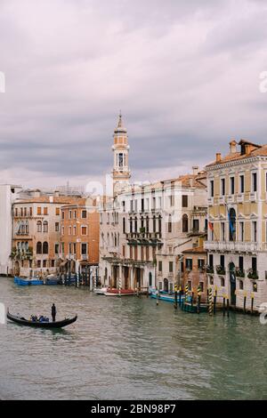 Venedig, Italien - 04. oktober 2019: Eine Gondel mit Touristen fährt entlang des Canale Grande inmitten der Fassaden venezianischer Häuser, die auf dem Wasser stehen Stockfoto