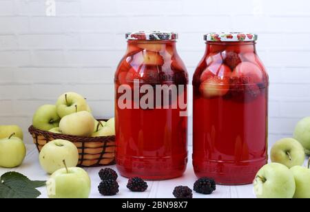 Kompott aus Brombeeren und Äpfeln in Gläsern auf weißem Hintergrund. Freier Platz für die Inschrift. Stockfoto