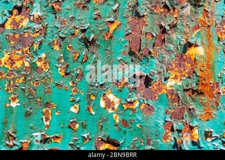 Fragment einer Metalloberfläche, die mit abblätternder grüner Farbe bedeckt ist, für die Verwendung als Textur für den Hintergrund. Stockfoto