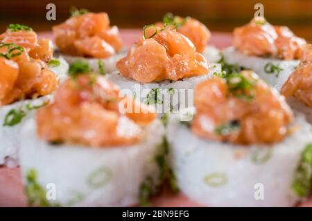 Drei Maki-Rollen in einer Reihe mit Lachs, Aal und Gurke auf weißem Hintergrund isoliert. Frische Hosomaki-Stücke mit Reis und Nori. Nahaufnahme von Delicious Stockfoto