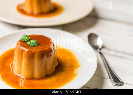 Nahaufnahme einer Flan Creme Karamellpudding mit Minze, ein Pudding Dessert. Stockfoto