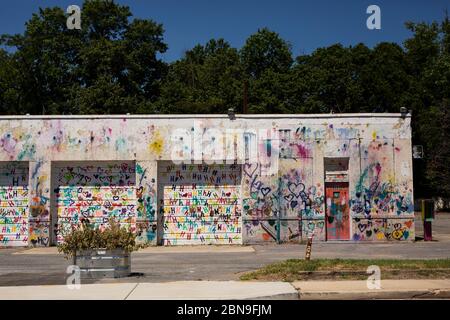 Ein altes Garagengebäude in der Hamilton Street in Hyattsville, Maryland, USA, bedeckt mit Graffiti des Buchstabens H und Herzen. Stockfoto