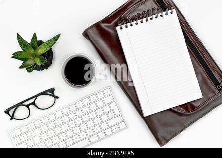 Online-Arbeit und Bildung Layout. Tastatur, Brille, Kaffeetasse, Notizblock und Laptop-Tasche. Copy Space Flatlay Stockfoto