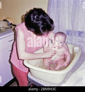 Baby Junge mit fünf Monaten bekommen ein Bad von seiner Mutter ca. 1967 Stockfoto