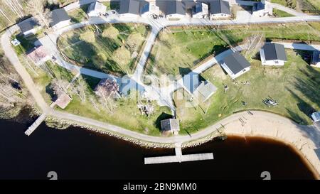 Luftaufnahme des Sees Borissowskoje, des Waldes und der Siedlung im Herbsttag, Borissowo, Leningrader Oblast, Russland Stockfoto