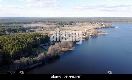 Luftaufnahme des Sees Borissowskoje, des Waldes und der Siedlung im Herbsttag, Borissowo, Leningrader Oblast, Russland Stockfoto