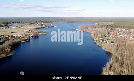 Luftaufnahme des Sees Borissowskoje, des Waldes und der Siedlung im Herbsttag, Borissowo, Leningrader Oblast, Russland Stockfoto