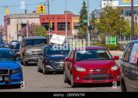 Detroit, Michigan, USA. Mai 2020. Ein Autokarawane passiert das Bürogebäude des Staates Michigan und fordert, dass Zwangsräumungen und Zwangsvollstreckungen während der Coronavirus-Pandemie gestoppt werden. Gov. Gretchen Whitmers Befehl zum Verbot von Räumungen endet am 15. Mai. Mitglieder der Detroit Eviction Defense wollen, dass bis 60 Tage nach dem Ausnahmezustand endet verlängert. Kredit: Jim West/Alamy Live News Stockfoto