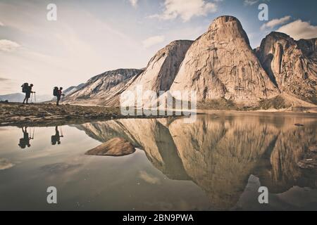 Silhouetten Spiegelung von zwei Rucksacktouristen gegenüber Berglandschaft. Stockfoto