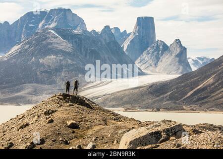 Rückansicht von Wanderern mit Blick auf die dramatische Bergaussicht vom Gipfel. Stockfoto