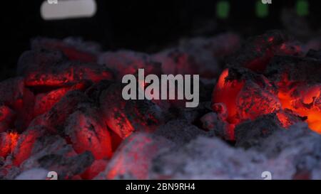Nahaufnahme von schwelenden Kohleflözchen im Grill. Geringe Schärfentiefe. Stockfoto