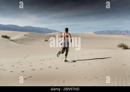 Ein Mann rennt im Wüstensand im Death Valley Stockfoto