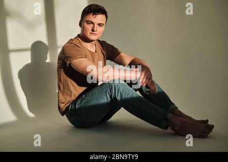 Schöner junger Mann allein in T-Shirt und Jeans Stockfoto
