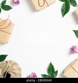 Geschenkboxen mit Rosenblüten auf weißem Hintergrund. Blumenmuster, flaches Lay, Draufsicht, Kopierraum Stockfoto