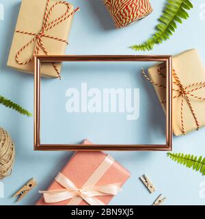 Textbereich für Jubiläumsnachricht. Leerer Bilderrahmen mit Geschenkboxen auf blauem Hintergrund. Draufsicht, Kopierraum Stockfoto