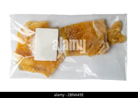 Getrocknetes Kabeljaufilet in einer transparenten Verpackung Vorspeise zu Bier auf weißem Hintergrund. Snack Fisch zu Bier. Nahaufnahme Stockfoto