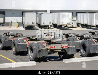 Reihe von industriellen Güterwagen mit Achsen und Sattelschlepper für Sattelzüge Züge stehen auf dem Lagerparkplatz mit Sattelauflieger Stockfoto