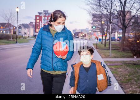 Novel Coronavirus COVID-19 verändert unser Leben in der Gesellschaft, Mutter und Sohn gehen auf den Boden mit Gesichtsmaske zu spielen Stockfoto