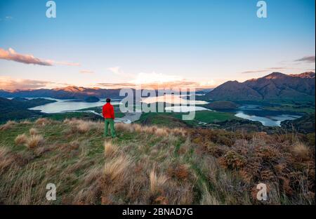 Walker blickt auf den Wanaka Lake und die Berge bei Sonnenuntergang, Rocky Peak, Glendhu Bay, Otago, South Island Stockfoto