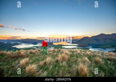 Walker blickt auf den Wanaka Lake und die Berge bei Sonnenuntergang, Rocky Peak, Glendhu Bay, Otago, South Island Stockfoto