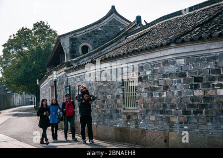 Eine chinesische Touristenfamilie geht an alten Gebäuden in Cicheng bei Ningbo, Provinz Zhejiang vorbei. Stockfoto