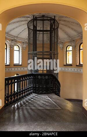 St. Petersburg, Russland - 25. Oktober 2014: Das Haupttreppeninterieur mit einem alten Aufzugsschacht, Obergeschoss. Vertikales Foto Stockfoto