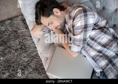 Bärtiger Mann im karierten Hemd schläft zu Hause. Stockfoto