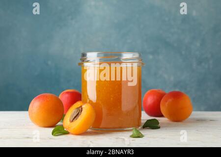 Komposition mit leckeren Aprikosen und Marmelade auf Holztisch Stockfoto