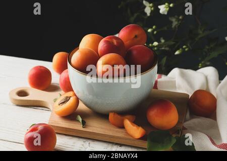 Komposition mit leckeren Aprikosen auf Holztisch vor dunklem Hintergrund Stockfoto
