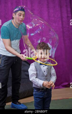 Seifenblasen zeigen. Kinderparty. Geburtstag der Kinder. Mit Seifenblase auf der Geburtstagsparty der Kinder spielen. Im Inneren der Seifenblase am Geburtstag Stockfoto