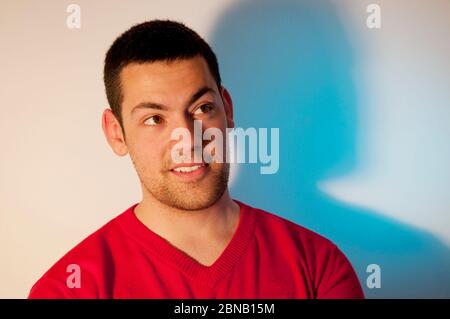 Junger Mann lächelnd und aufblickend. Stockfoto