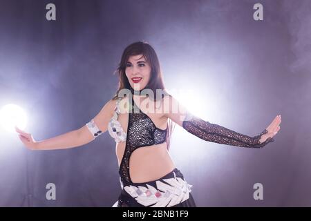 Junge Frau, die im Tribal Fusion Stil tanzt. Bauchtanz auf der Bühne. Stockfoto