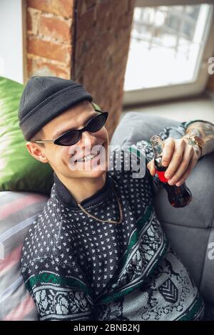 Porträt von Millennial Junge mit Retro-Stil, Treffen Dinge aus der Vergangenheit und Spaß haben. Generation of Digital Devices untersucht vergangene Unterhaltung der 90er Jahre. 90-s trendy Look, Jugend. Cola trinken. Stockfoto