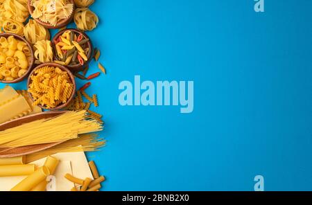 Verschiedene Pasta-Typen auf blauem Hintergrund mit Kopierplatz für Text Stockfoto