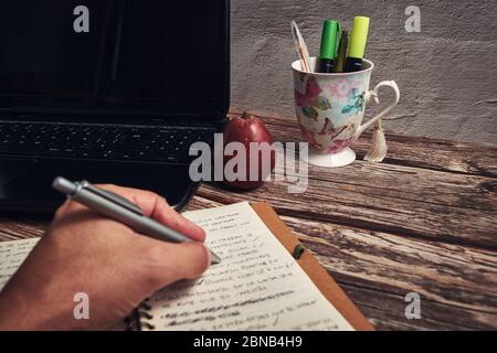 Notebook-Computer Marker und roter Apfel auf dem Holztisch Stockfoto