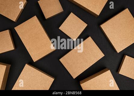 Braune Pappkartons auf schwarzem Hintergrund, Draufsicht Stockfoto