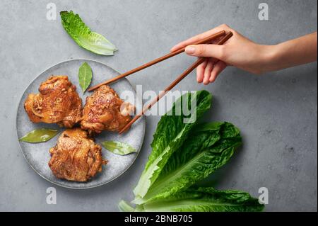 Filipino Chicken Adobo auf grauer Platte auf Betonhintergrund. Chicken Adobo ist philippinische Küche Gericht aus geschmorten Hähnchenschenkel, Sojasauce, Essig, schwarz Stockfoto