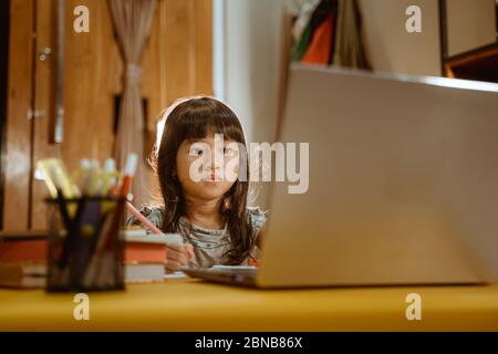 Junge Kinder lernen, indem sie Laptop zu Hause am Abend Stockfoto