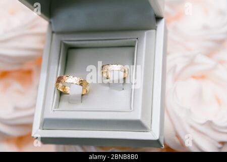 Nahaufnahme von zwei goldenen Eheringen in Weiß Feld Stockfoto