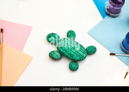 Schritt für Schritt eine Steinschildkröte auf einem Stein malen. Kinder Kunstprojekt. DIY-Konzept. Schritt für Schritt Fotoanleitung. Stockfoto