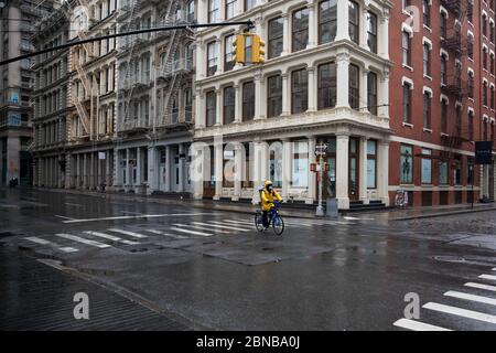 Peking, USA. Mai 2020. Ein Liefermann, der eine Gesichtsmaske trägt, geht an geschlossenen Einzelhandelsgeschäften in New York, USA, 8. Mai 2020 vorbei. Kredit: Michael Nagle/Xinhua/Alamy Live News Stockfoto