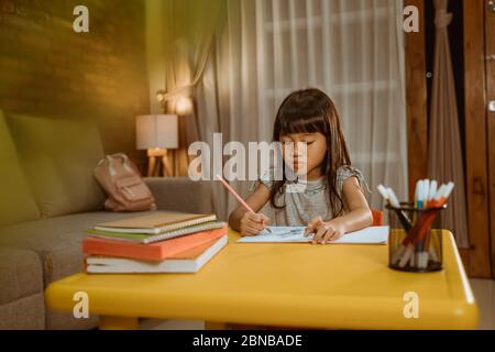 Mädchen lernen am Abend. asiatische kleine Kind zu Hause Schreiben auf ein Buch lernen Stockfoto