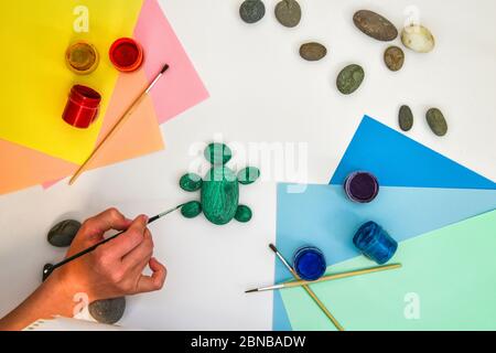Schritt für Schritt eine Steinschildkröte auf einem Stein malen. Kinder Kunstprojekt. DIY-Konzept. Schritt für Schritt 3 Stockfoto