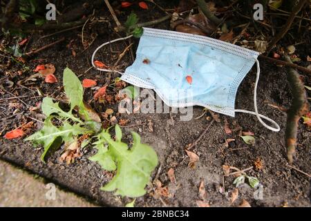 Hamburg, Deutschland. Mai 2020. Ein Mundschutz (Mund- und Nasenmaske) liegt in den Büschen entlang einer Straße. Kredit: Bodo Marks/dpa/Bodo Marks/dpa/Alamy Live News Stockfoto