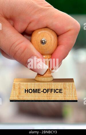 Stempel in der Hand einer Frau mit Schriftzug Home-Office, Deutschland Stockfoto