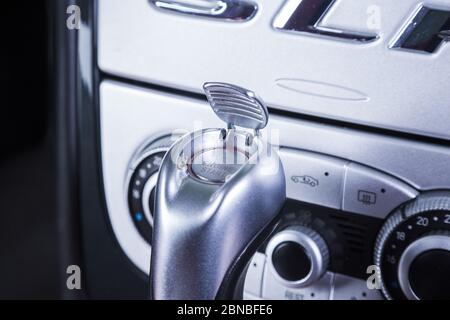 Nahaufnahme eines silbernen Zahnradgriffs in einem Auto Mit einem weißen Dashboard als Hintergrund Stockfoto